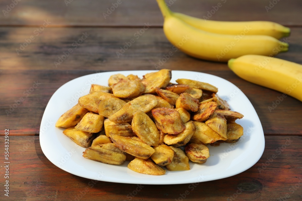 Tasty deep fried banana slices on wooden table
