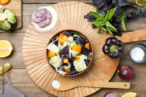 Delicious salad with Chinese cabbage, tomato and basil served on wooden table, flat lay