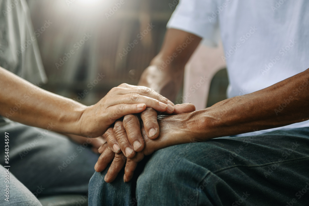 Fototapeta premium Hands of the old man and a woman hand on the wood table