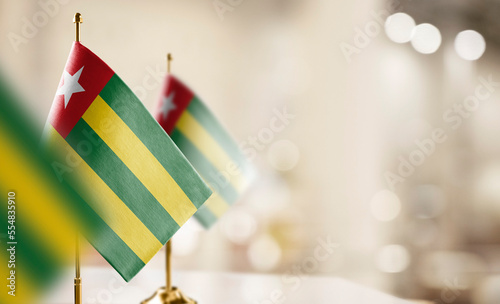 Small flags of the Togo on an abstract blurry background photo