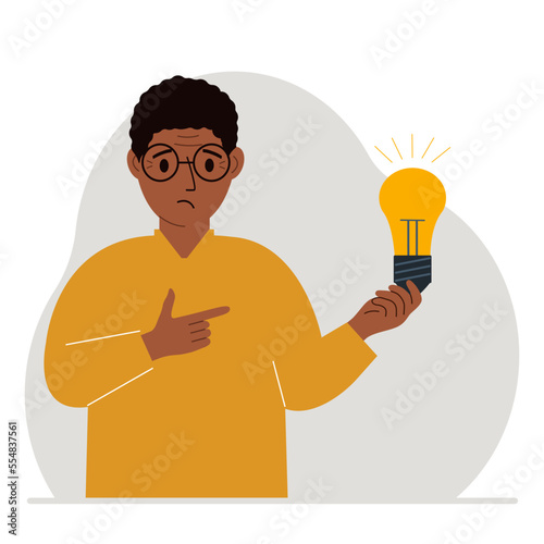 A man holds a light bulb in his hand. Idea concept, brainstorming, business, thinking, solution, eureka, task, bingo or answer search.