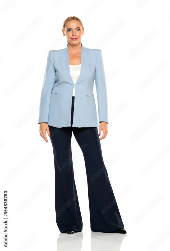 Middle aged senior woman wearing blue jacket and black trousers on a white studio background Middle aged senior woman wearing blue jacket and black trousers on a white studio background