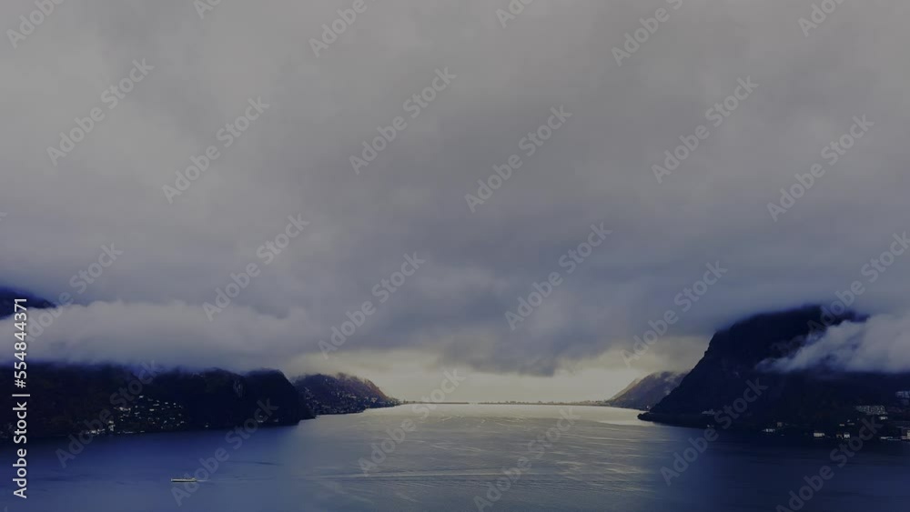Storm Clouds over Lake Lugano with Mountain Range View and Sunlight in Lugano, Ticino, Switzerland. Storm Clouds over Lake Lugano with Mountain Range View and Sunlight in Lugano, Ticino, Switzerland.