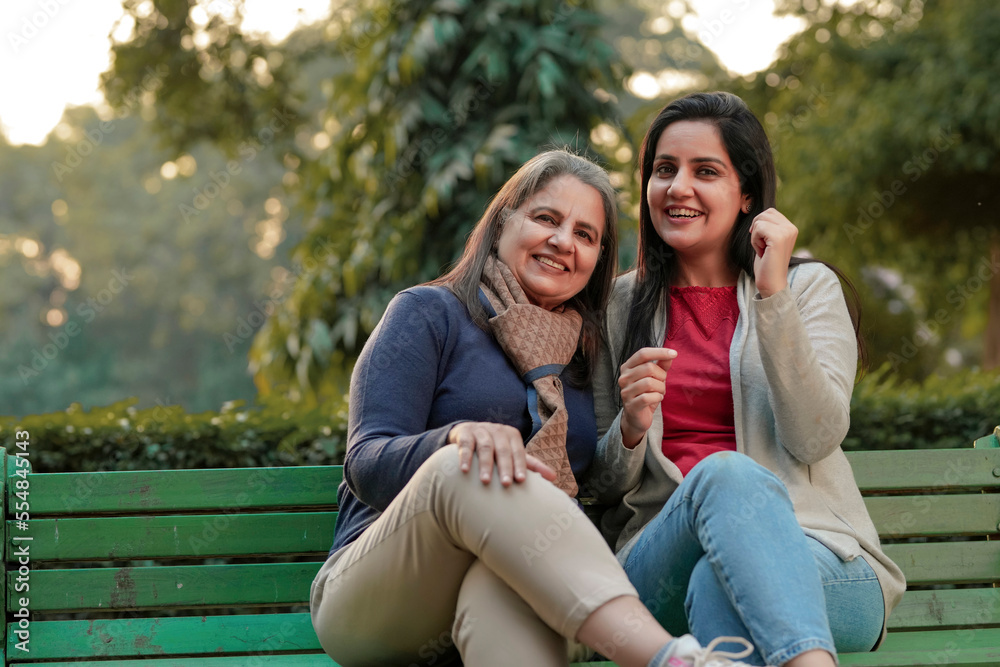 Two indian woman sitting at park in winter wear Two indian woman sitting at park in winter wear