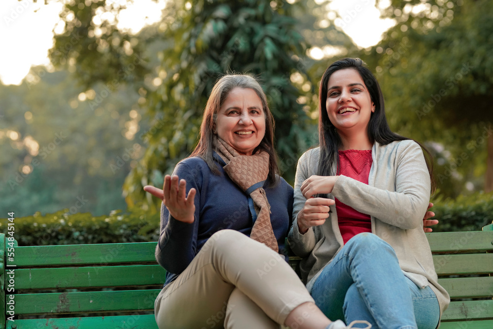 Two indian woman sitting at park in winter wear Two indian woman sitting at park in winter wear
