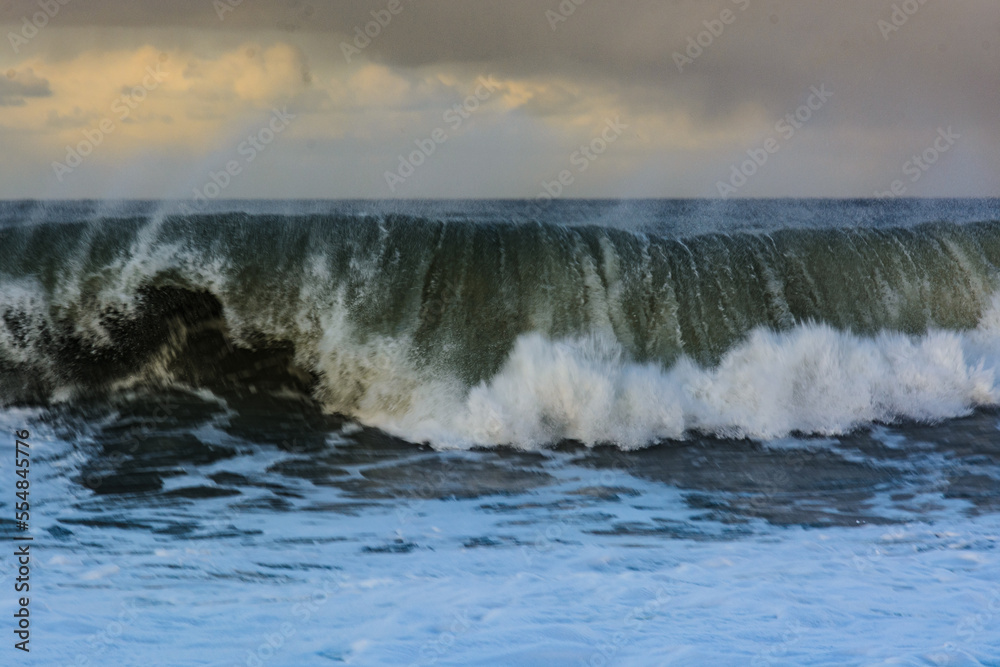 violent steep waves crashing onto a sandy beach during winter. Shot in Denmark