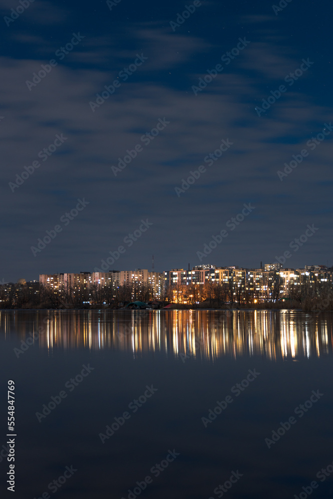 Fototapeta premium Scenic view of the city of Dnepr in the winter evening. Dnipro in the evening. Ukrainian city in winter at night. background image. Panoramic view. Long exposure photo of the Dnieper River at night.