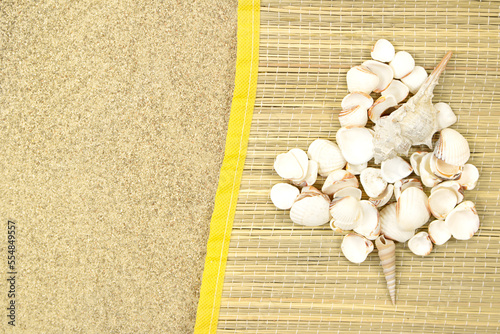 Heart made of white shells on straw lounger on sand with space for text. Valentine's day, travel, vacation. Copy space photo