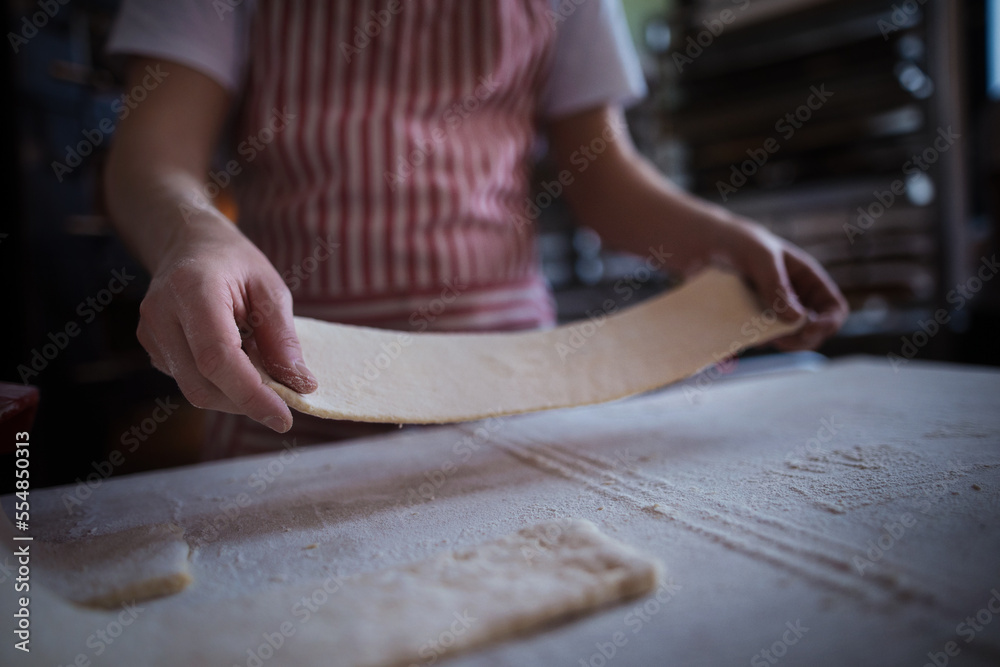 Close-up of baker preparing pastries in bakery. Close-up of baker preparing pastries in bakery.