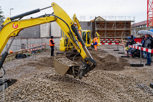 Bild auf Leinwand Open day at highway enclosure construction site at Zürich Schwamendingen with excavator exercising on a rainy autumn day