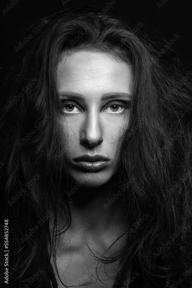 Fashion and make-up concept. Studio portrait of beautiful woman with eye shadows, long and dark dreadlocks hair looking at camera with seductive look. Studio shot black and white image