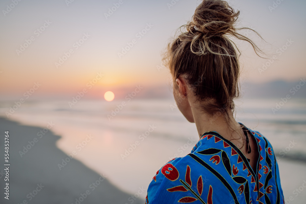 Fototapeta premium Rear view of young woman enjoying time at sea.