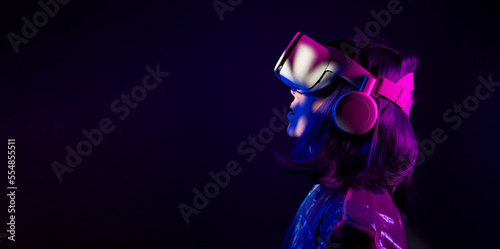 Woman in virtual reality goggle in neon colors. photo