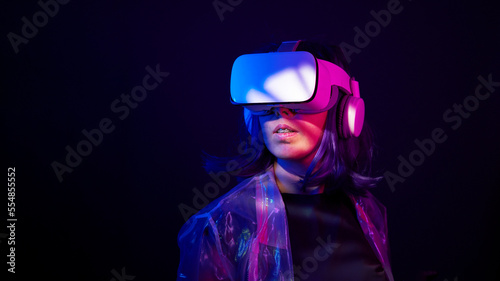 Woman in virtual reality goggle in neon colors.