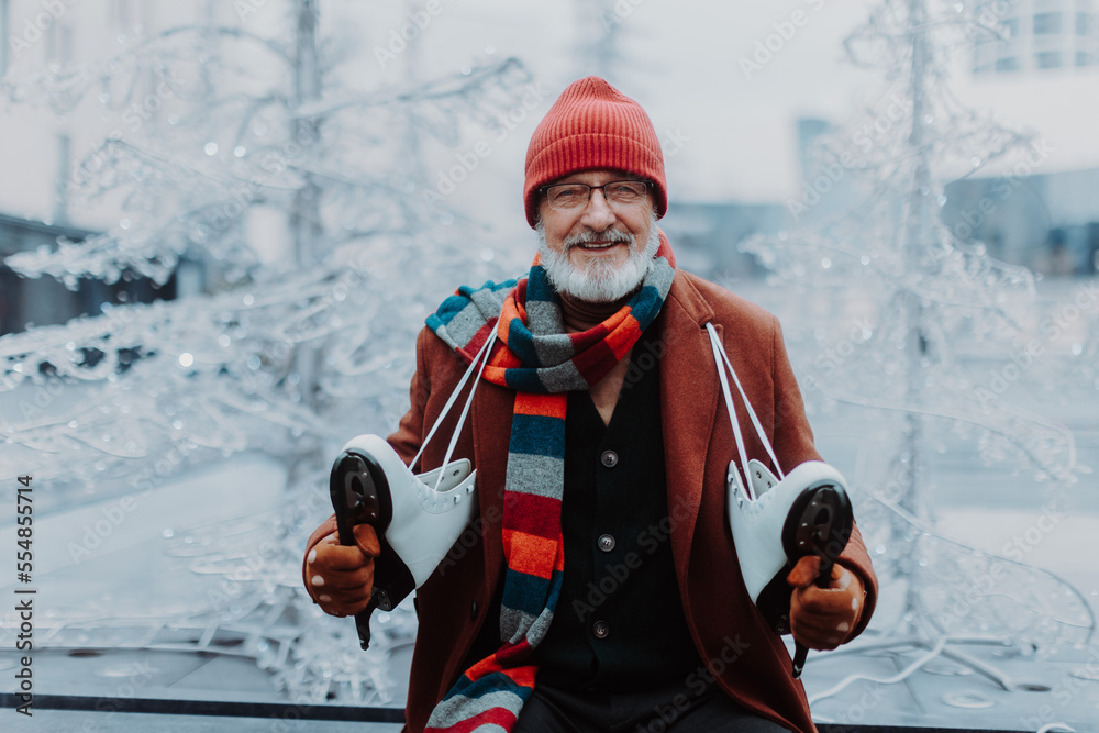 Portrait of happy senior man in winter at outdoor ice skating rink.