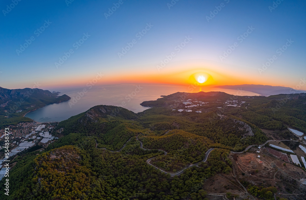 Aerial view winding road in middle forest and sea Turkey sunset time
