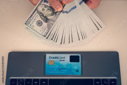 man holds a dollar bill to shop online via the Internet, Using a credit card instead of cash concept. return on investment, online work, manager salary photo