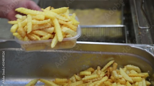 French fries are fried in a large pot. close up. Street food festival. Potatoes Fried in oil.