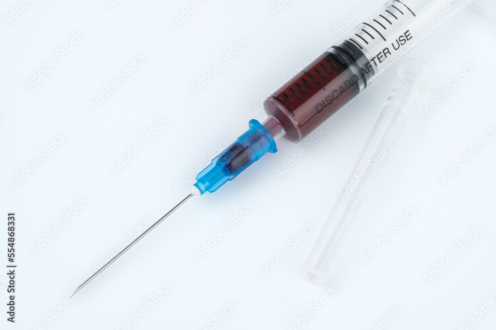A syringe with blood for a blood test. Medical syringe with dark liquid. Drugs. Vitamins. Medicines. A syringe with blood for a blood test. Medical syringe with dark liquid. Drugs. Vitamins. Medicines.