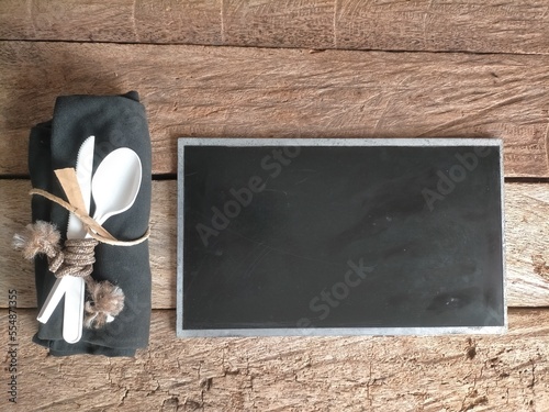 blackboard with fork and spoon on wood background 