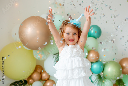 little girl celebrating birthday catches confetti