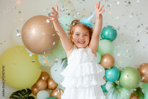 little girl celebrating birthday catches confetti