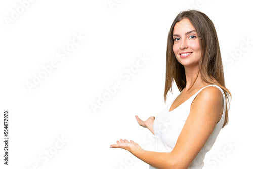 Young pretty woman over isolated background extending hands to the side for inviting to come