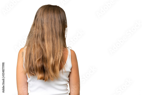 Young pretty woman over isolated background in back position and looking side