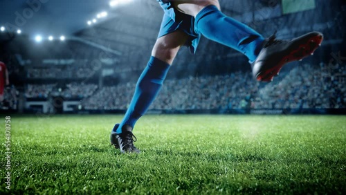 Football World Championship: Soccer Player Runs, Kicks the Ball. Ball Shoots, Grass Sprays Outwards, Full Stadium Crowd Cheers. Camera Moves in Arc Super Slow Motion. Cinematic Shot Captures Victory