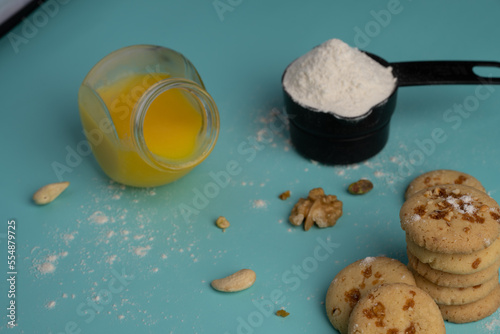 Freshly baked butterscotch cookies with its ingredients like dry fruits cow ghee and maida