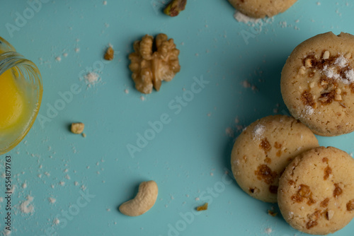 Freshly baked butterscotch cookies with its ingredients like dry fruits cow ghee and maida