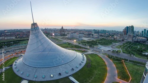 Aerial view over the city center with Khan Shatyr and central business district night to day transition timelapse before sunrise time from rooftop, Kazakhstan, Astana, Central Asia photo