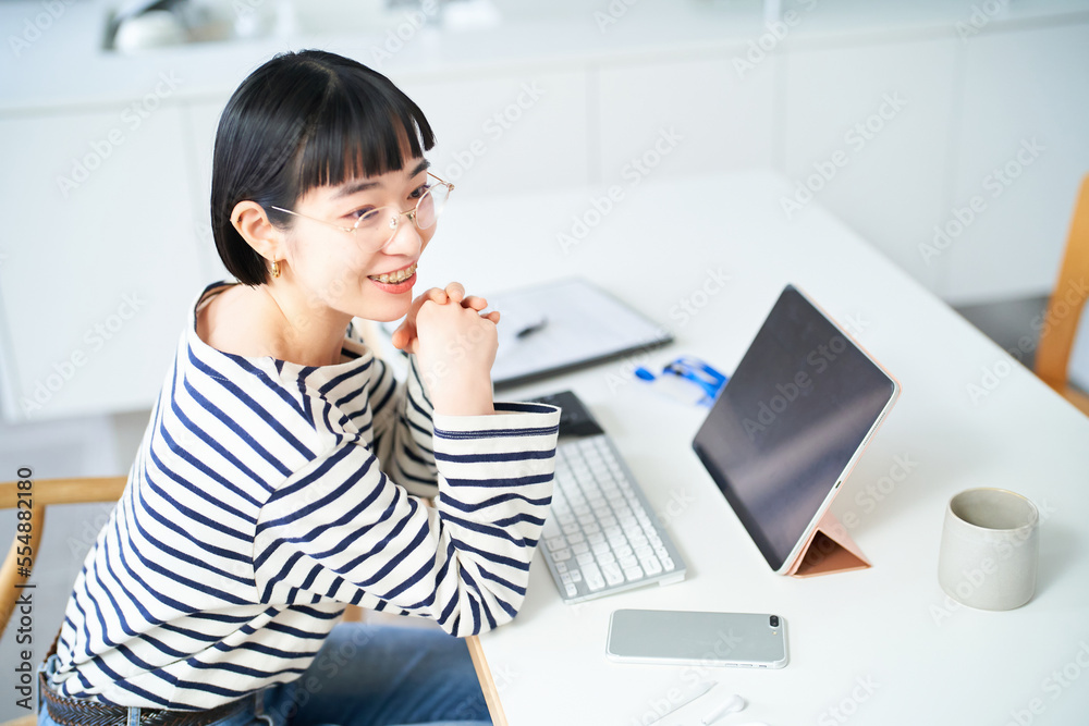 部屋のテーブルで仕事をする若い女性 部屋のテーブルで仕事をする若い女性