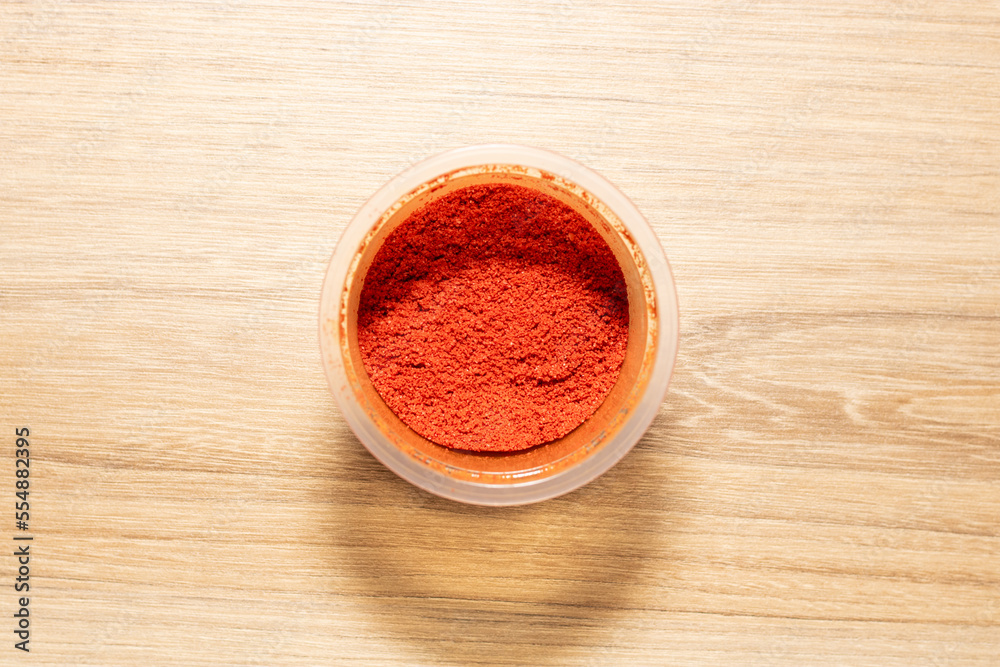 Paprika powder for seasoning. High quality photo on wooden table Paprika powder for seasoning. High quality photo on wooden table