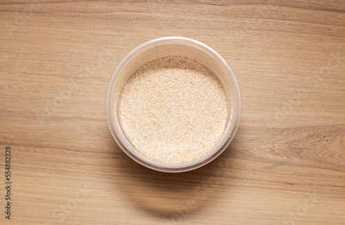 Grain oats in transparent container. High quality photo on wooden table