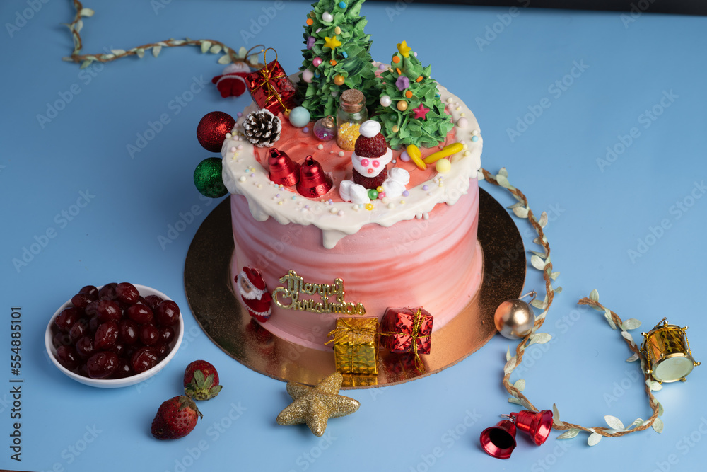 Christmas cake decorated with sweet figures of Christmas tree, Santa, bears, deer, fir-tree