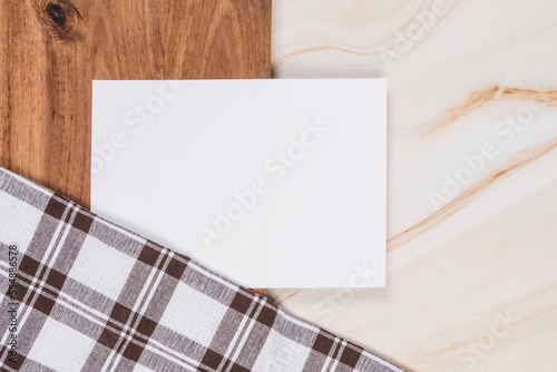 white paper on wood table on marble background with checkered cloth photo