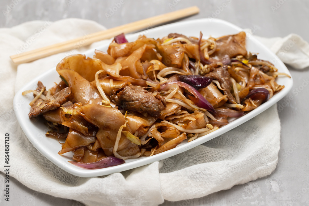 Fried noodles with vegetables and beef in white dish Fried noodles with vegetables and beef in white dish