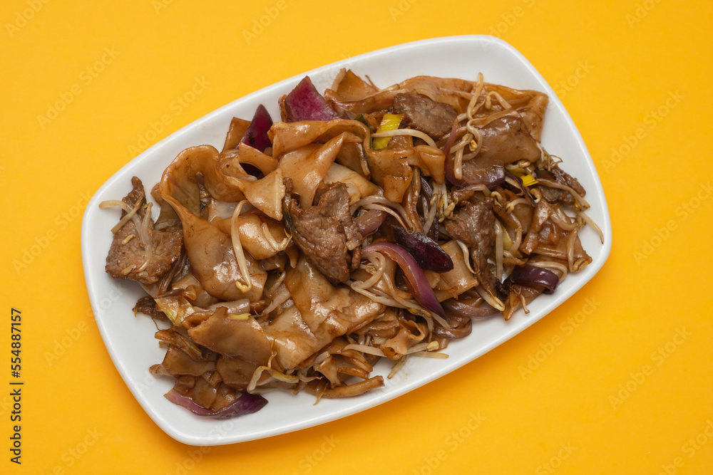 Fried noodles with vegetables and beef in white dish Fried noodles with vegetables and beef in white dish