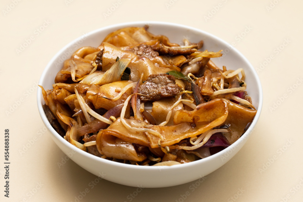 Fried noodles with vegetables and beef in white bowl Fried noodles with vegetables and beef in white bowl