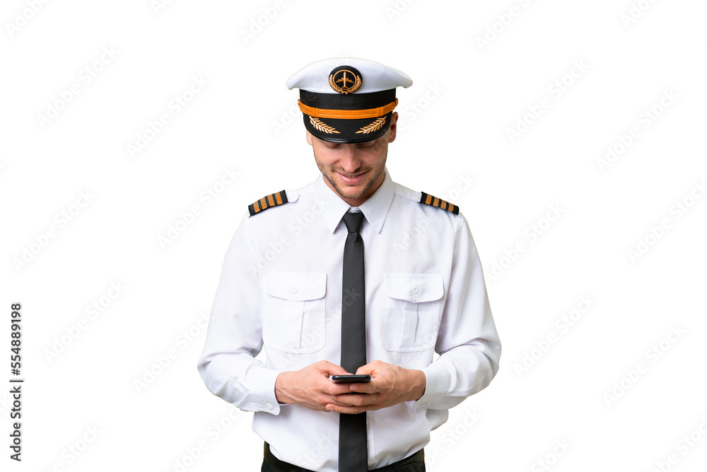 Airplane pilot man over isolated background sending a message with the mobile Airplane pilot man over isolated background sending a message with the mobile