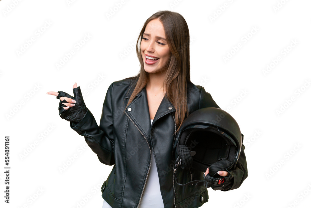Young pretty caucasian woman with a motorcycle helmet over isolated background pointing finger to the side and presenting a product Young pretty caucasian woman with a motorcycle helmet over isolated background pointing finger to the side and presenting a product