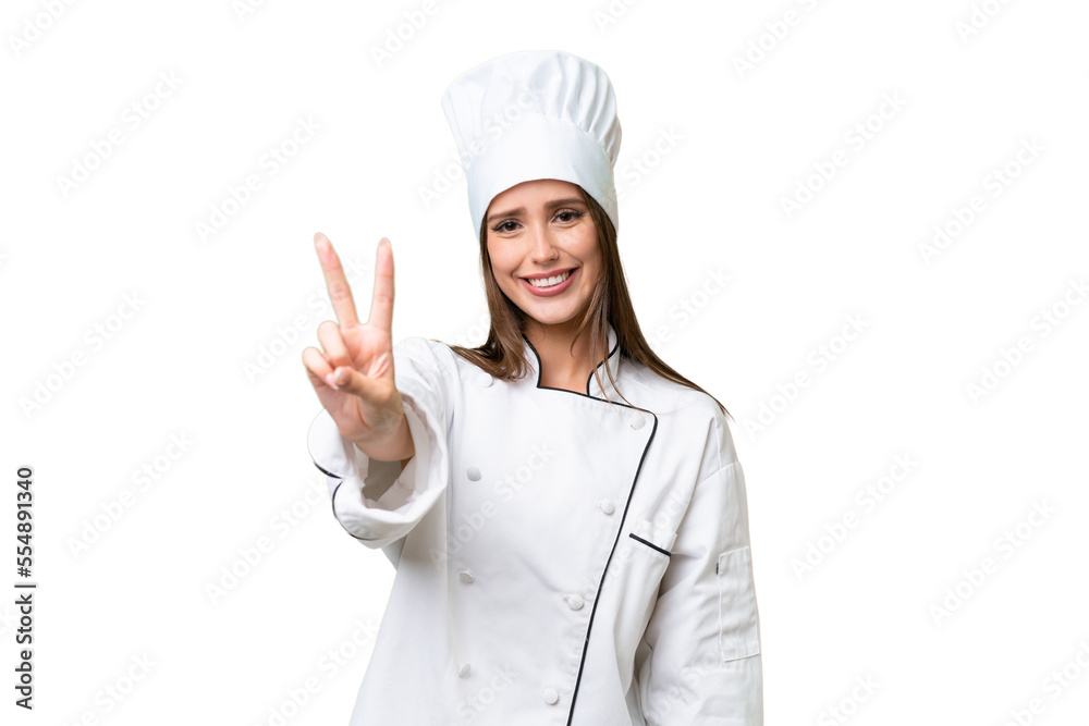 Young chef caucasian woman over isolated background smiling and showing victory sign Young chef caucasian woman over isolated background smiling and showing victory sign