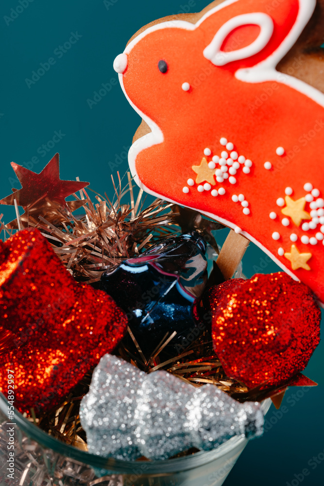 Naklejka premium Glass with Christmas decorations on dark green background