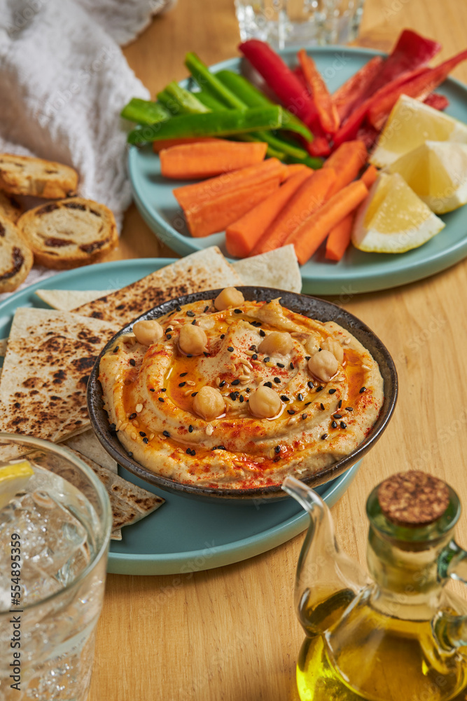 Hummus and tortilla chips near vegetables and lemonade Hummus and tortilla chips near vegetables and lemonade