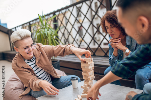 Company of three people involved in playing a board game