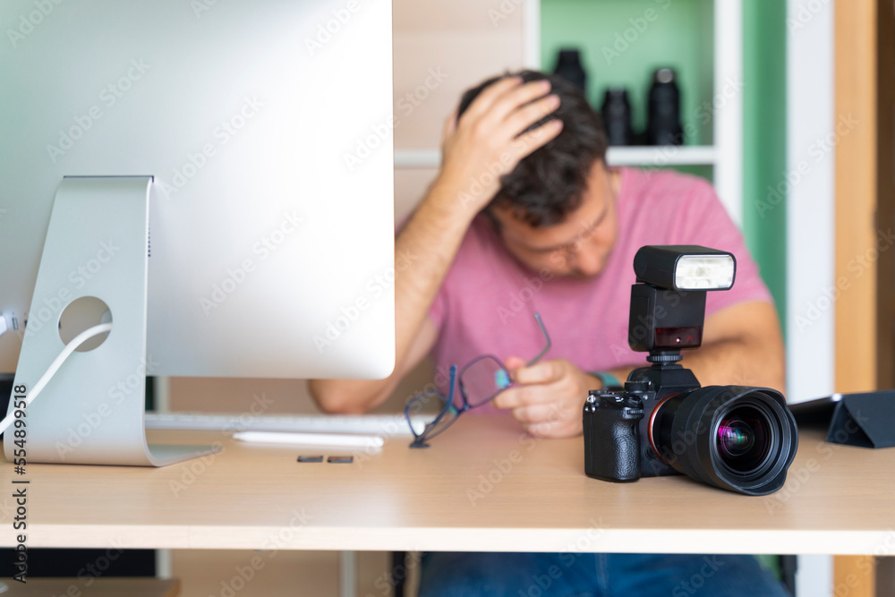 Man in his office worried about his photos on the computer Man in his office worried about his photos on the computer