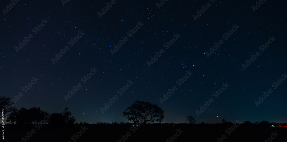 Naklejka premium Universe filled with stars, nebula and galaxy with noise and grain.Photo by long exposure and select white balance.Dark night sky.
