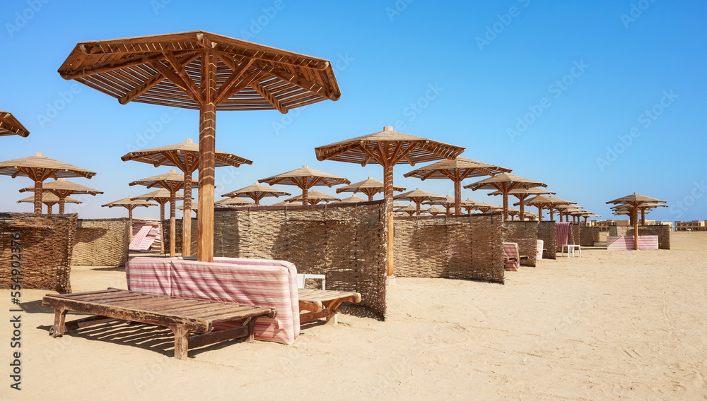 Wooden beds and umbrellas on a tropical beach.