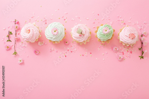 pink and green cupcakes with spring flowers  on pink  background